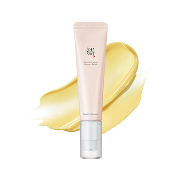 Skincare tube with yellow cream smear on a white background